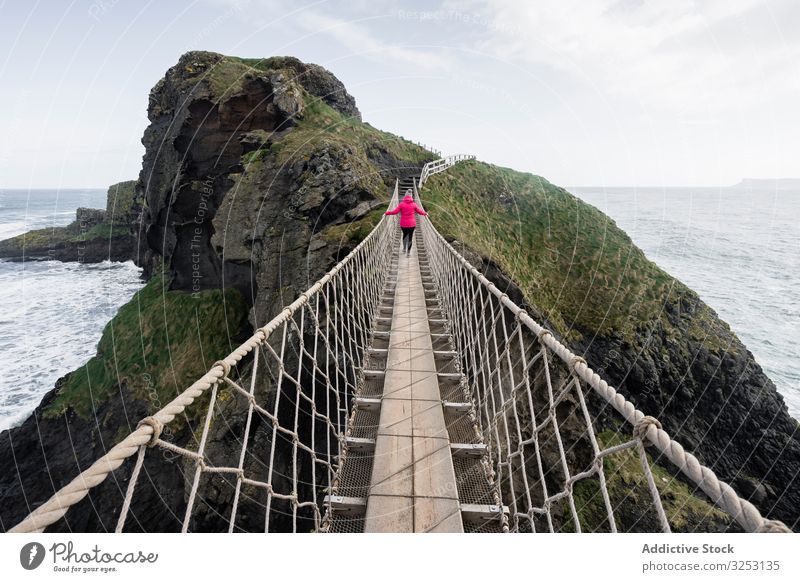 Frau überquert Seilbrücke zur Felseninsel Brücke MEER Insel Spaziergang Meer Nordirland durchkreuzen Küste carric a red Ufer Wasser Landschaft Selbstvertrauen