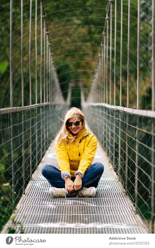Fröhliche Touristin steht im Sommer auf Hängebrücke Frau Steg Wald heiter Urlaub Suspension Sommerzeit Tourismus erhängen reisen Reise Natur Abenteuer Park