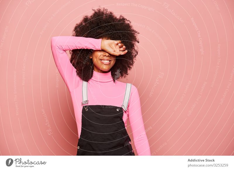 Junge afroamerikanische Frau, die mit dem Arm die Augen bedeckt deckende Augen Lächeln Überraschung Warten aufgeregt Glück rosa Lachen heiter schüchtern Scham