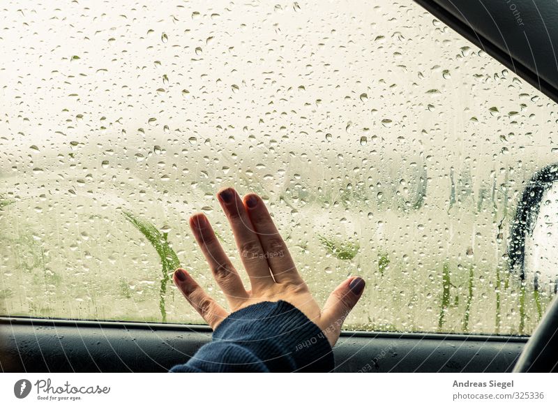 Hand wischt über beschlagene Autoscheibe im Regen beschlagene Scheibe Autofenster Wassertropfen Tropfen Tristesse Regentropfen schlechtes Wetter melancholie