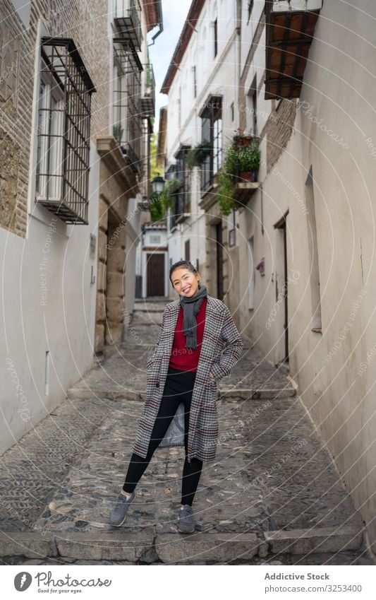Fröhliche Touristin in Freizeitkleidung mitten auf der Straße Frau reisen Spaziergang Großstadt erkunden Lächeln Fahrspur genießen lässig jung Feiertag