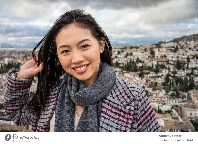 Fröhliche ethnische Frau besucht antike Stadt Großstadt Tourismus wolkig Himmel Lächeln stylisch trendy Architektur asiatisch reisen Ausflug Glück heiter