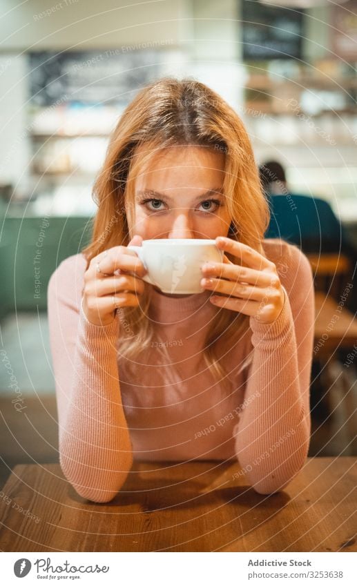 Frau bei einer Tasse Kaffee Café trinken Smartphone benutzend Lächeln modern Browsen Gerät Apparatur soziale Netzwerke Surfen zuschauend erfreut Glück heiter