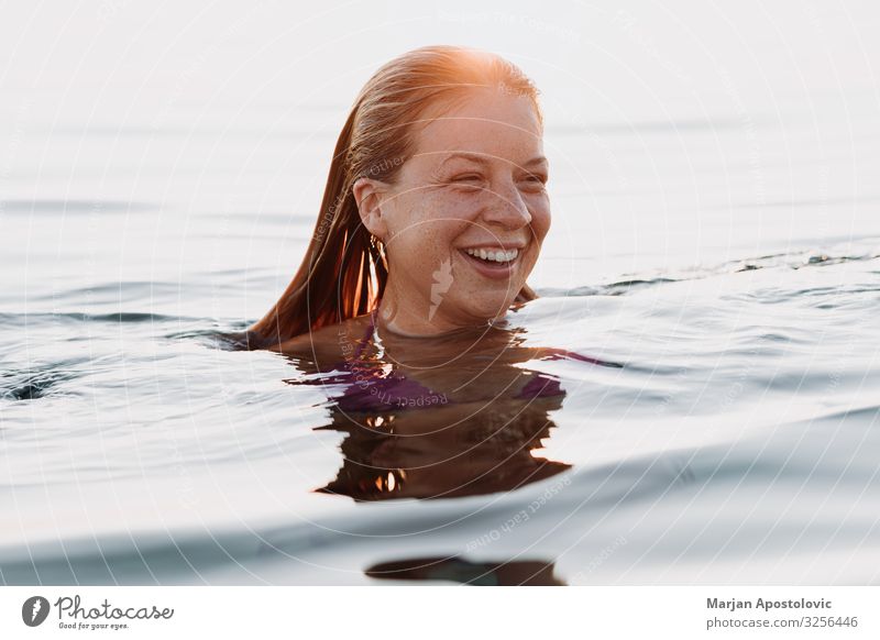 Junge glückliche Frau schwimmt bei Sonnenuntergang im Meer Lifestyle Freude Ferien & Urlaub & Reisen Tourismus Freiheit Sommer Sommerurlaub Mensch feminin