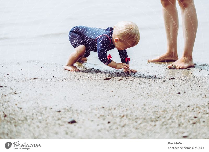 Kleinkind spielt mit Sand am Strand Kind spielen Mutter Füße Mädchen Mutter mit Kind