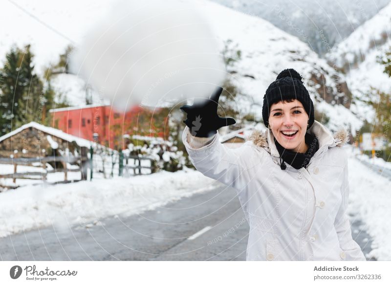 Lächelnde Frau spielt mit Schnee auf dem Land Schneeball Landschaft spielen Winter Freude Berge u. Gebirge ruhen Resort Feiertag Natur Dorf ländlich kalt Spaß