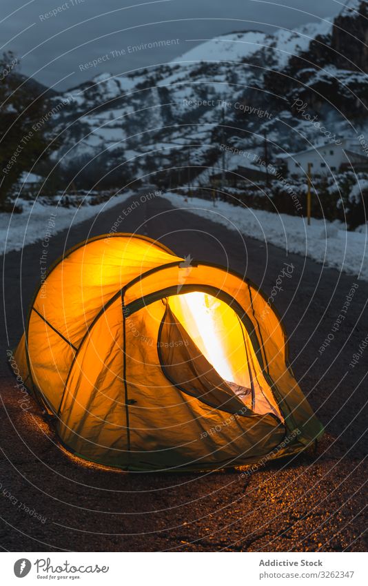 Beleuchtetes Zelt in der Mitte der asphaltierten Straße Winter Berge u. Gebirge Tourismus Dämmerung Licht Abend Schnee Asphalt gemütlich Abenteuer Natur