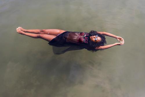 Schöne junge afrikanische Frau schwimmt an einem Wasserbecken Lifestyle Freude schön Erholung Schwimmbad Freizeit & Hobby Spielen Ferien & Urlaub & Reisen