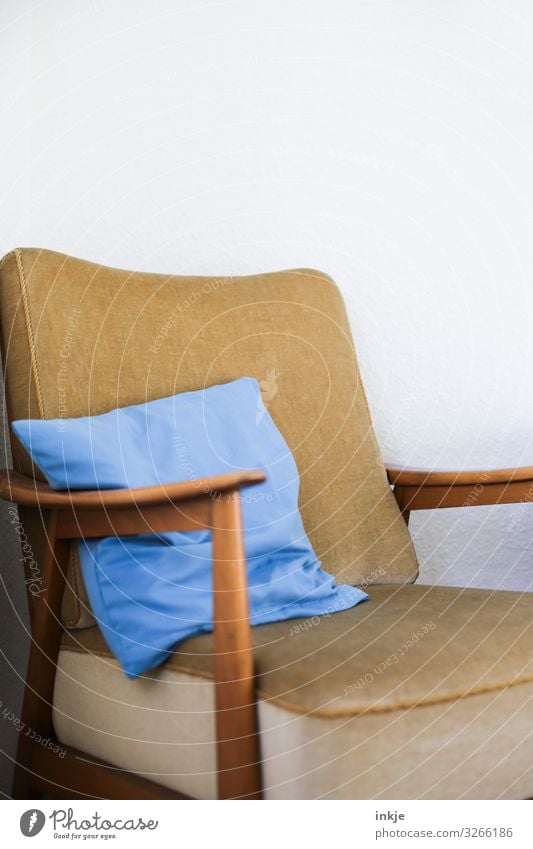 alter Sessel mit hellblauem Kissen Farbfoto Innenaufnahme detailaufnahme Nahaufnahme Designermöbel Menschenleer Textfreiraum braun beige weiß