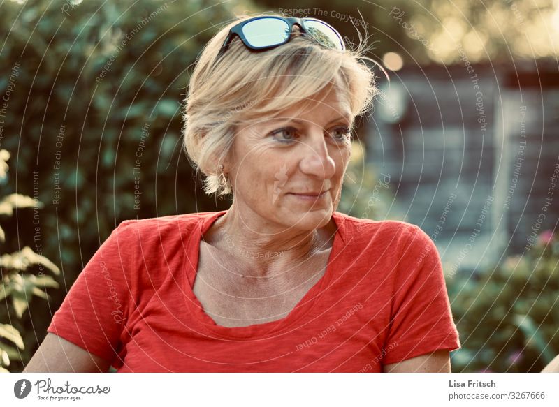 BEOBACHTEN - FRAU - ROT - SOMMER Frau Erwachsene 1 Mensch 45-60 Jahre Sommer Schönes Wetter Garten Sonnenbrille blond kurzhaarig beobachten Lächeln