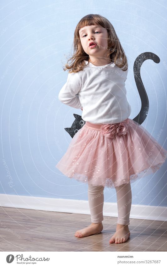 Junges Mädchen spielt ein fantasievolles Spiel auf blauem Hintergrund. Einfache Grafik einer Katze hinter dem Kind versteckt. Freude Glück Spielen Abenteuer