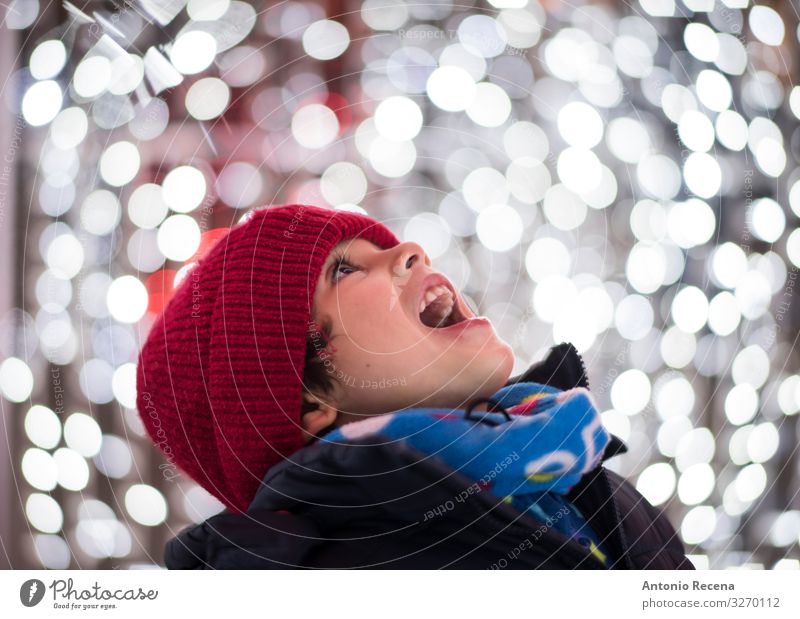 Jungen Kopfbild Portrait mit Weihnachtslichtern Freude Winter Feste & Feiern Kind Mensch Schal Hut Lächeln weiß Gefühle Begeisterung Überraschung Weihnachten