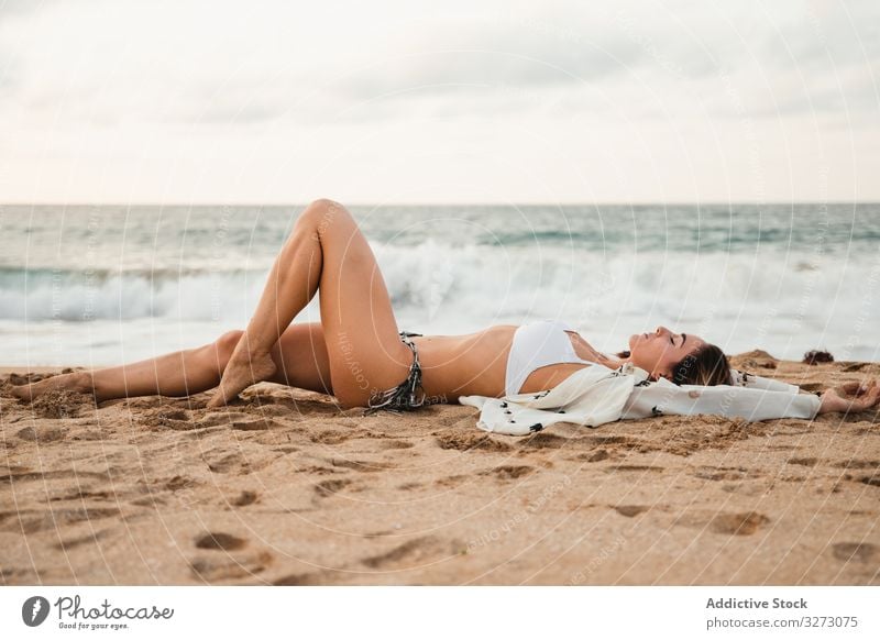 Frau ruht sich an bewölktem Tag am Sandstrand aus Spaziergang Strand MEER Wasser wolkig Himmel Urlaub Resort Wochenende Sommer Lifestyle ruhen
