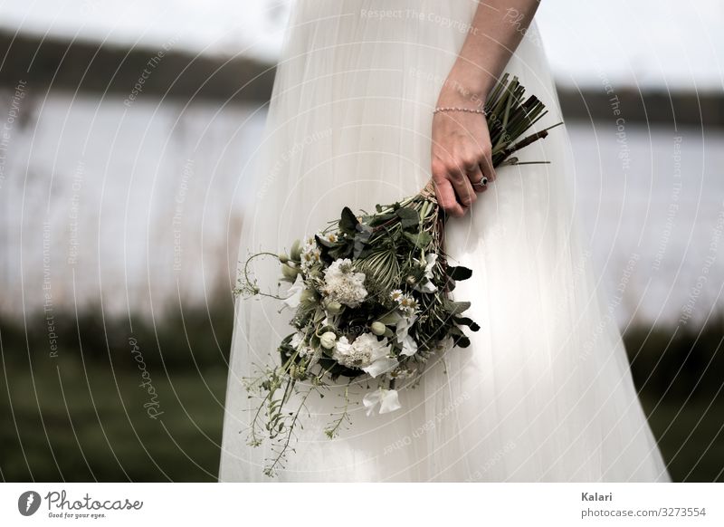 Braut hält weißen Brautstrauss am See brautkleid brautstrauss moody wiese unscharf blume hochzeit frau schön bewegungsunschärfe romantik jung florist natur