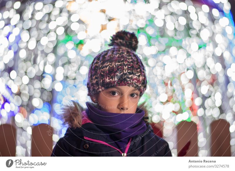Porträt eines schüchternen Mädchens mit Weihnachtslichtern Lifestyle Freude Winter Dekoration & Verzierung Kind Kindheit Wärme Mantel Schal Hut niedlich