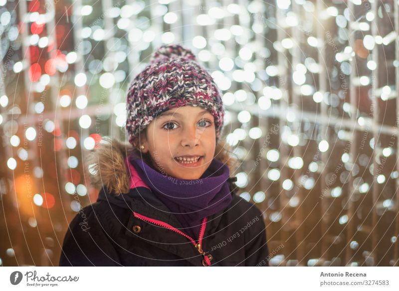 Lächelndes Mädchen mit Weihnachtslampenblitzen Lifestyle Freude Winter Dekoration & Verzierung Kind Kindheit Wärme Mantel Schal Hut lachen niedlich Gefühle