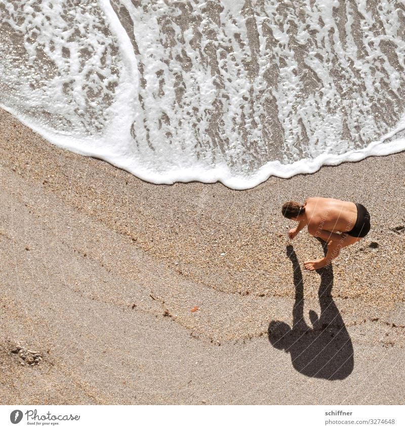 Mann sammelt Muscheln am Strand Wellen Wellengang suchen suchend gebückt gebückte Haltung Schatten Schattenwurf sammeln sammelnd jäger und sammler Meer