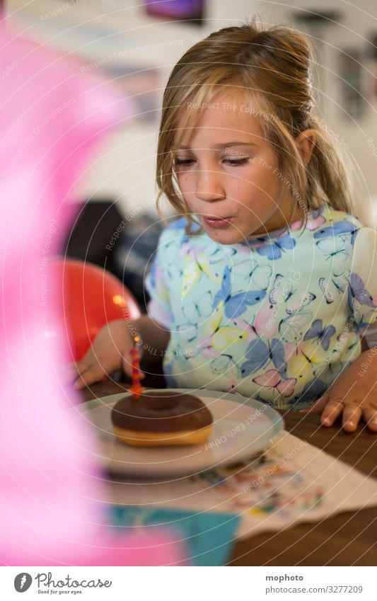 Mädchen im Kleid bläst Kerze auf Doughnut aus Einschulung Feier Schule Schulkind ausblasen doughnut erste klasse erster Schultag fest kleid schulanfang