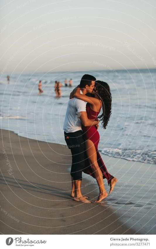 Pärchen küsst sich am Strand bei Sonnenuntergang Sommer Meer Mensch Paar 2 18-30 Jahre Jugendliche Erwachsene Schönes Wetter Kleid langhaarig Sand Küssen Liebe