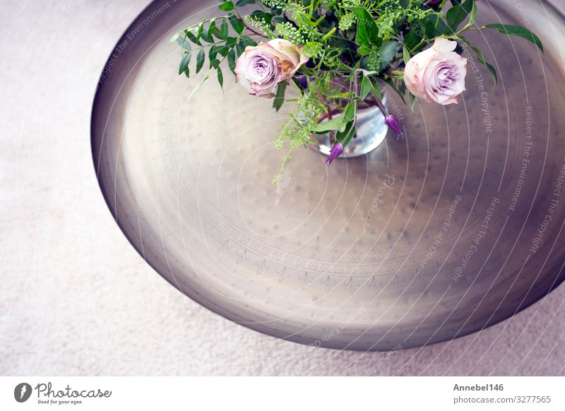 Silbernes Tablett mit violetten Rosen in Vase auf einem Tisch gegen Luxus Schalen & Schüsseln Reichtum Design Körper Behandlung Leben Spa Blume Blüte Mode Holz