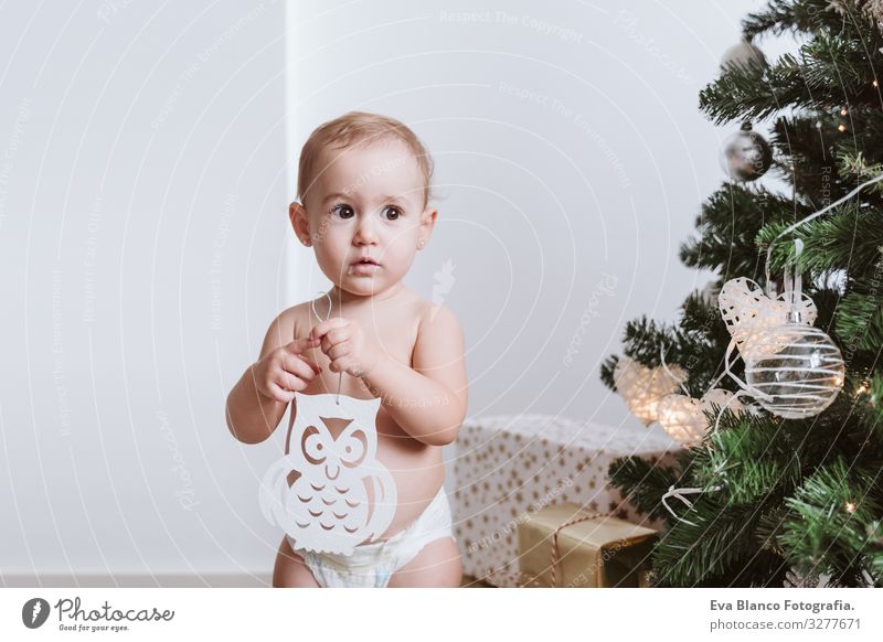 süßes Mädchen mit Windel, das den Weihnachtsbaum schmückt Windeln Glück niedlich Baby ein Jahr dekorierend Weihnachten & Advent Baum Freude