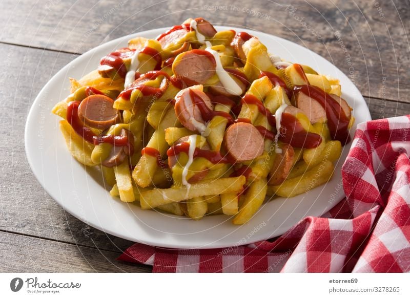 Typisch lateinamerikanischer Salchipapa. Würstchen mit Pommes Frites, Ketchup schwarz Abendessen Fastfood dick Fett Lebensmittel Foodfotografie Pommes frites