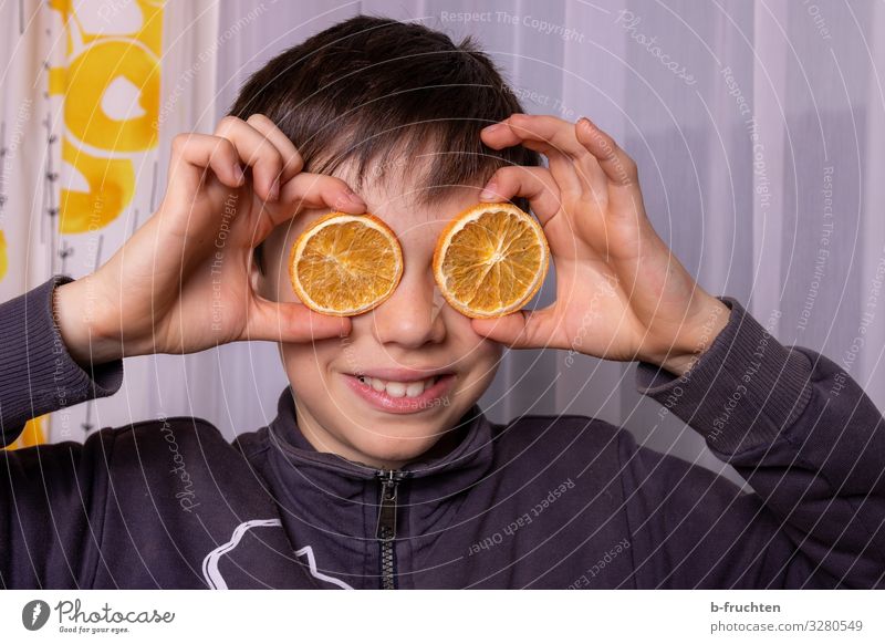 Kind mit Orangenscheiben Junge Gesicht Hand 1 Mensch 8-13 Jahre Kindheit Brille gebrauchen berühren festhalten Lächeln lachen Blick Spielen Fröhlichkeit Freude