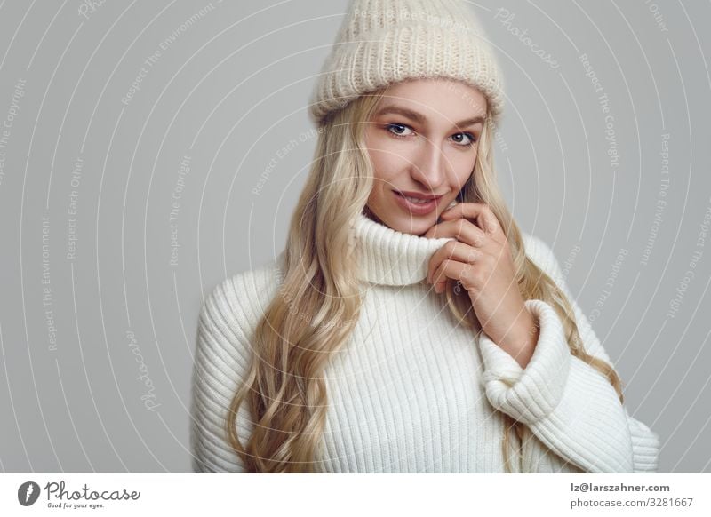 Wunderschöne Frau in weißem Strickpullover und Mütze Glück Gesicht Winter Erwachsene 1 Mensch 18-30 Jahre Jugendliche Wärme Pullover Hut blond Lächeln modern