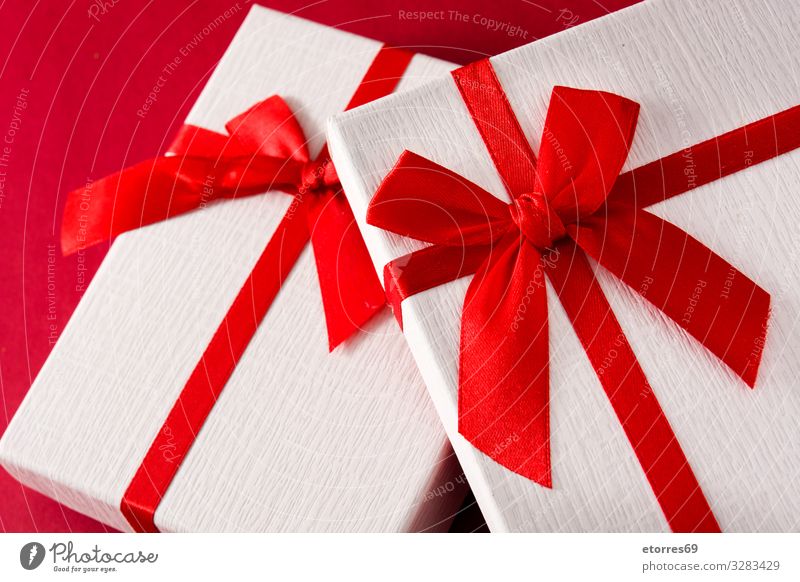 Sortierte weiße Geschenkverpackungen auf rotem Hintergrund. Weihnachten & Advent Kasten Schachtel Schleife Schnur Gegenwart Geburtstag Ferien & Urlaub & Reisen