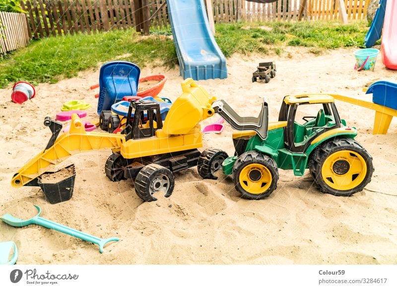 Buntes Spiezeug im Sandkasten Freude Spielen Kinderspiel Sommer Strand Kindergarten Natur Spielzeug Kunststoff positiv gelb grün Hintergrundbild Bagger