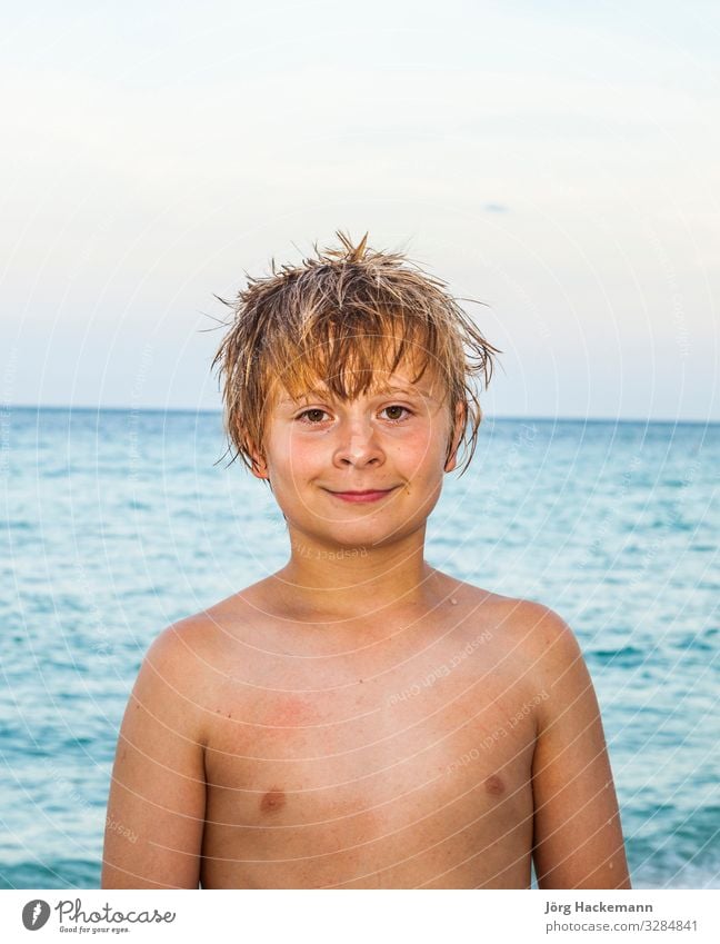 Porträt eines süßen lächelnden Jungen am Strand unter blauem Himmel Freude Glück schön Körper Haut Gesicht Erholung Freizeit & Hobby Ferien & Urlaub & Reisen