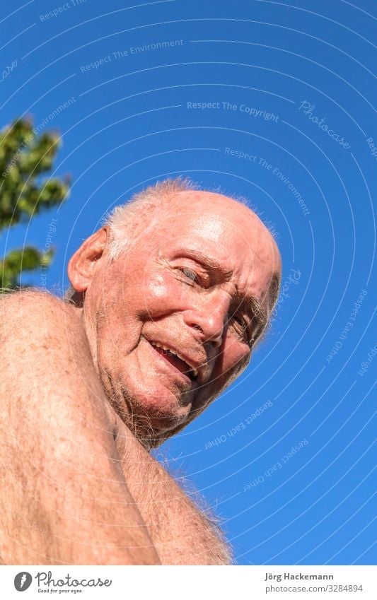 der Senior sitzt auf dem Stuhl im Garten Lifestyle Freude Glück Erholung Sommer Sonne Ruhestand Mann Erwachsene Großvater Natur Himmel alt Lächeln blau grün