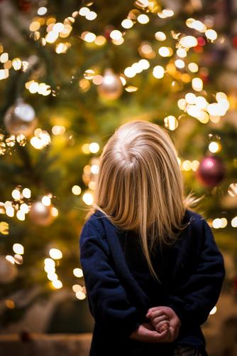 Weihnachten - Kind steht ehrfürchtig vor einem Weihnachtsbaum Ehrfurcht Freude Begeisterung vorfreude niedlich Glaube Weihnachtsmann Mädchen Lichterkette corona