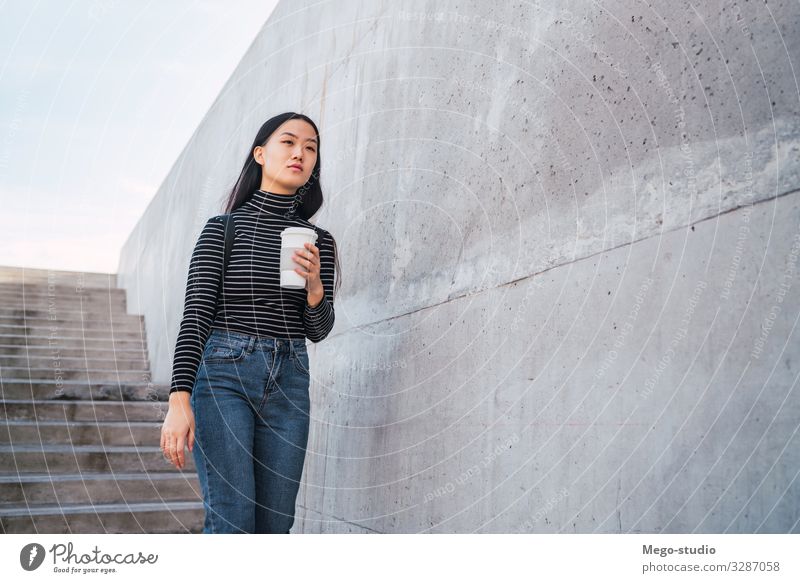 Asiatische Frau mit einer Tasse Kaffee in der Hand. trinken Lifestyle Stil Glück schön Beruf Mensch Erwachsene Straße brünett gehen Lächeln modern asiatisch