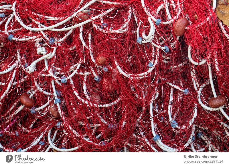 Netzwerk mit Hilfe von sardischen Fischernetzen in Rot mit weißen Kordeln und blauen Ringen Fischereiwirtschaft Fischfang rot Leine Tau Seil Maschen Knoten