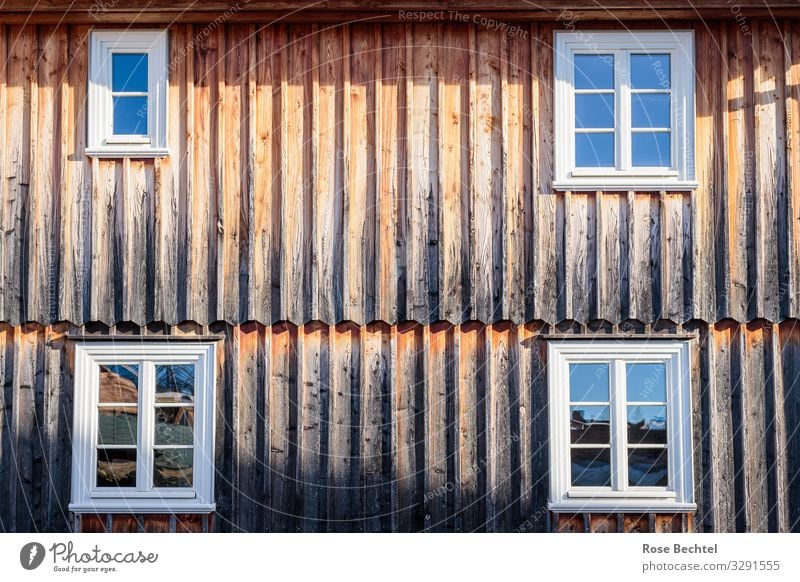 Vier Fenster Haus Holzfassade alt eckig einfach nachhaltig Wärme braun Farbfoto Außenaufnahme Textfreiraum Mitte Tag Reflexion & Spiegelung Sonnenlicht