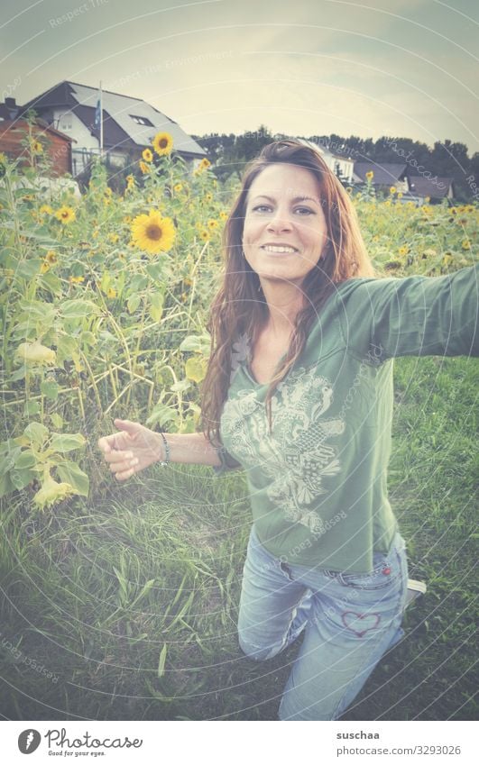 frau macht ein selfie vor einer sonnenblumenwiese Frau Hippie lange Haare Blumenmädchen weiblich Selfie Wiese Blumenwiese Sonnenblumen Ortschaft Haus