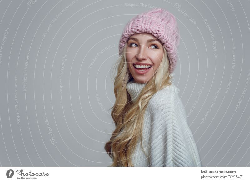 Lächelnde junge Frau mit rosa gestrickter Wintermütze Glück schön Gesicht Erwachsene 1 Mensch 18-30 Jahre Jugendliche Wärme Wald Wege & Pfade Pullover Hut blond