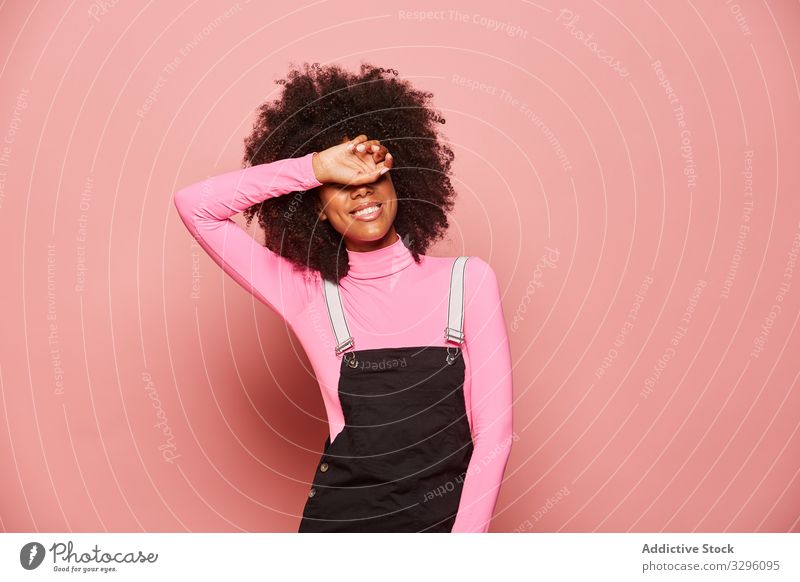 Junge afroamerikanische Frau, die mit der Hand die Augen bedeckt deckende Augen Lächeln Überraschung Warten aufgeregt Glück rosa Lachen heiter schüchtern Scham