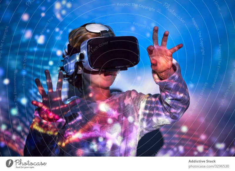 Kind trägt zu Hause eine virtuelle Brille mit Farblichteffekten Technik & Technologie Realität Freizeit Kindheit Entertainment Frau Headset Mädchen bezaubernd