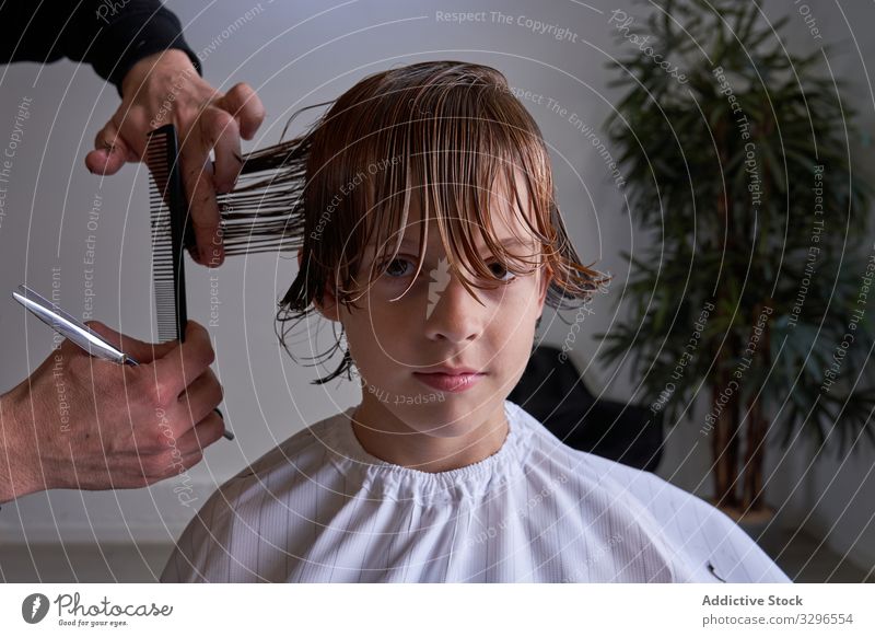 Junge schneidet seine Haare beim Friseur geschnitten Barbershop Kind jung Behaarung Mode Salon Frisur Trimmen Frau Haarschnitt Sitzen Schönheit beliebt Stuhl