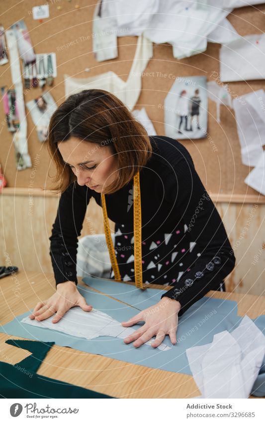 Schneiderin schneidet Tuch auf dem Tisch Damenschneiderin geschnitten Gewebe Detailaufnahme Frau Schere Arbeit Werkstatt Mode Bekleidung Textil Designer