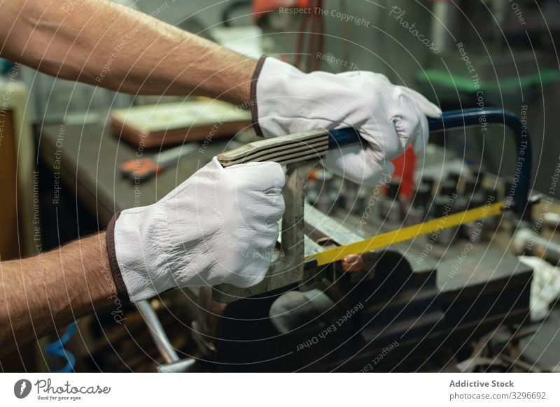 Gesichtsloser Vorarbeiter mit Bügelsäge in der Werkstatt Polier benutzend Mechaniker Handschuhe Säge Metall Detailaufnahme Arbeit Fabrik männlich Gerät