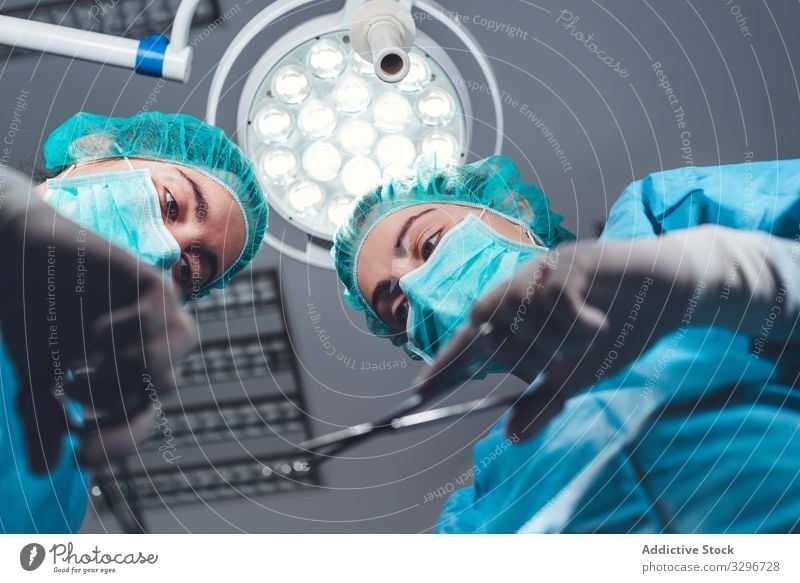 Frauen, die gemeinsam im Krankenhaus operieren Chirurg Operationssaal Lampe Werkzeug Mundschutz Hut Arbeit Arzt Gesundheitswesen steril Instrument Zusammensein