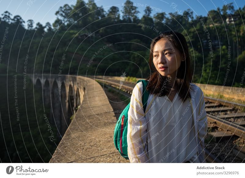 Nachdenkliche Asiatin geht in alter altertümlicher Brücke entlang der Eisenbahn Frau grün Wald nachdenklich antik asiatisch Brücke mit neun Bögen schäbig ella