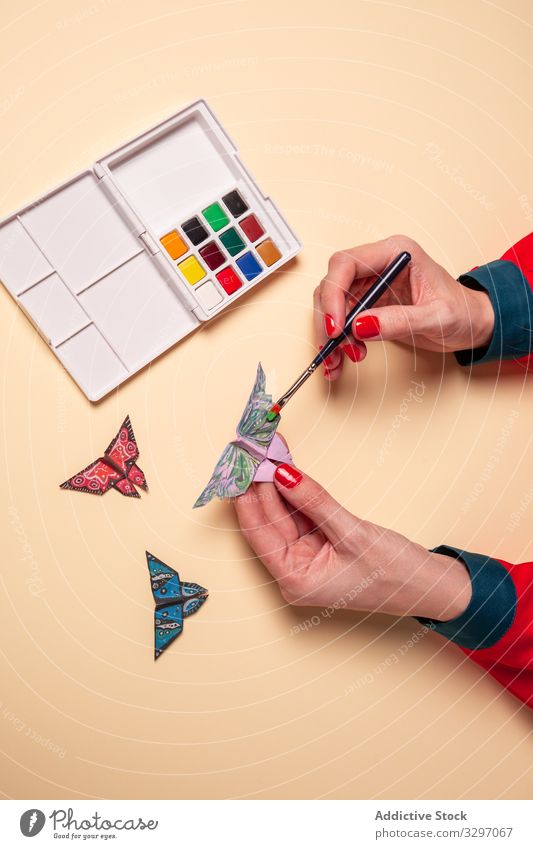 Getreidefrau malt Papier-Schmetterlinge Frau Origami Farbe Konzept Kunst Wasserfarbe Ornament kreativ Bürste Insekt Wanze Flügel Dekor Design vorsichtig