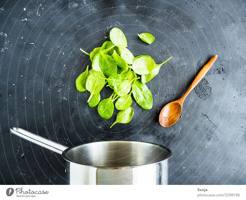 Kochtopf mit frischen Blattspinat und Kochlöffel Lebensmittel Gemüse Spinat Ernährung Mittagessen Abendessen Bioprodukte Vegetarische Ernährung Diät Topf Löffel