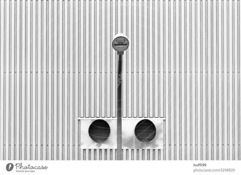 symmetrische Ansicht einer Strassenlaterne vor zwei Lüftungsröhren mit Wellblechfassade Industrieanlage Bauwerk Gebäude Mauer Wand Fassade Metall Stahl Linie