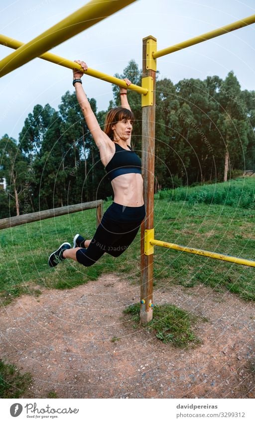 Sportlerin bei Klimmzugübungen Lifestyle Körper Mensch Frau Erwachsene Arme Natur Park Turnschuh Fitness dünn stark Kraft anstrengen Energie