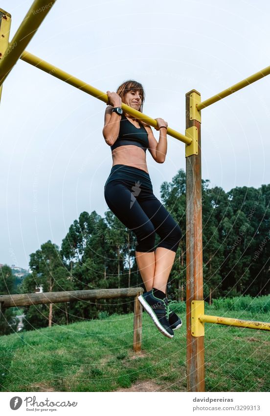 Sportlerin bei Klimmzugübungen Lifestyle Körper Mensch Frau Erwachsene Arme Natur Park Turnschuh Fitness hängen dünn stark Kraft anstrengen Energie Athlet